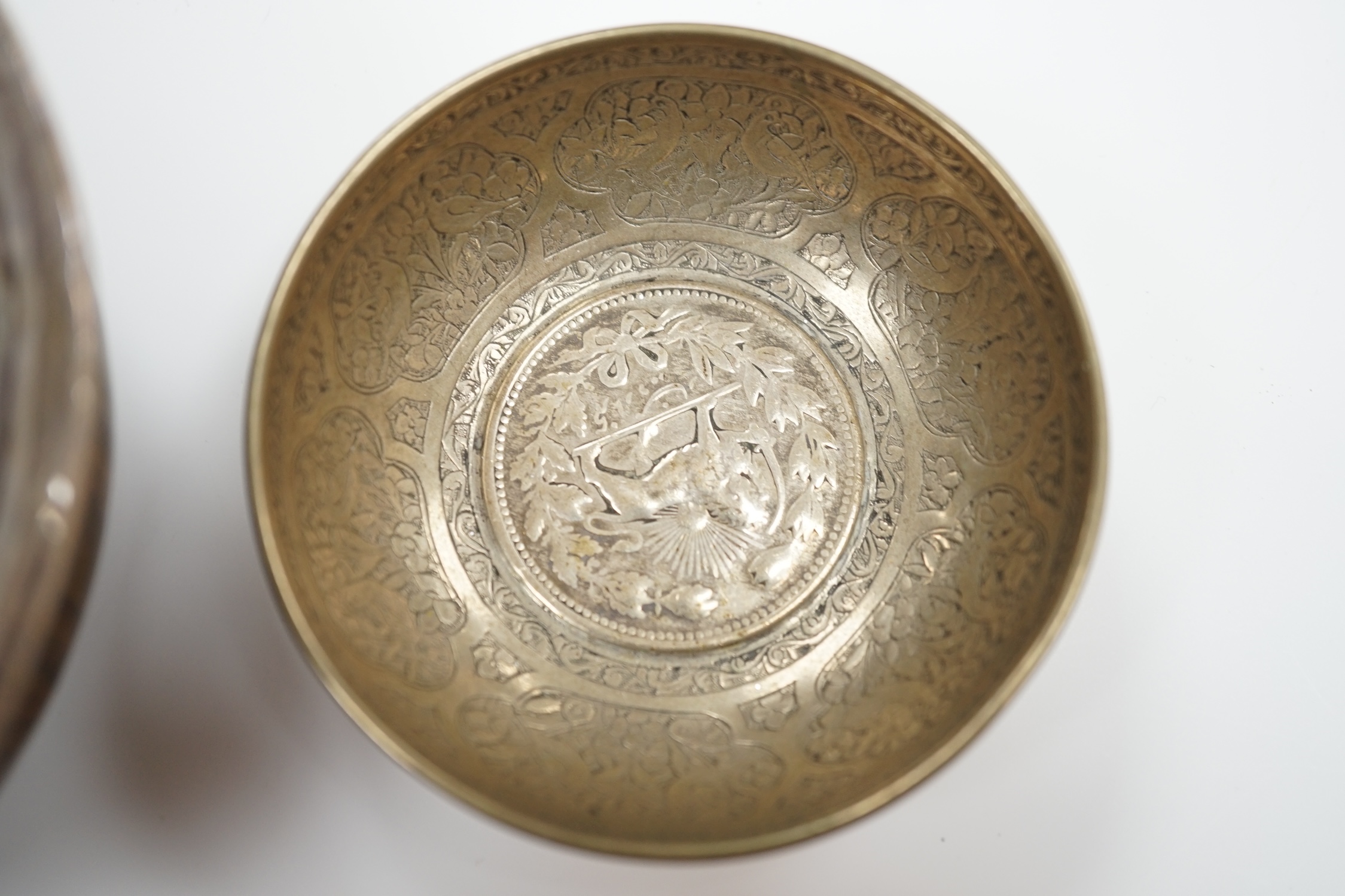 A Tibetan white metal mounted cup, two coin inset dishes and a silver matchbox holder, largest 11.5cm diameter